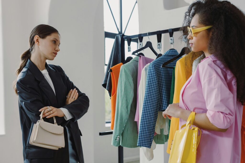 Why Scaling Feels Messy Even When Things Are “Working” Two women browsing colorful clothing racks in a modern boutique.